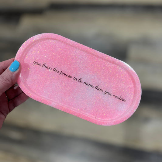 Pink and white glitter resin tray with quote “you have the power to be more than you realize,” held in hand