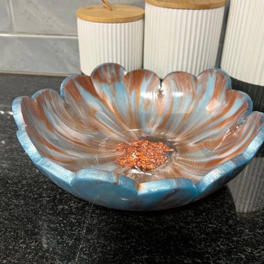 Decorative resin fruit bowl with metallic detail in center, displayed on a dark kitchen counter